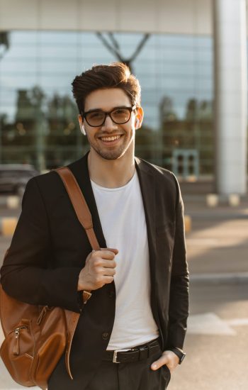 happy-businessman-in-eyeglasses-looks-into-camera-and-smiles-sincerely-brunette-guy-in-black-jacke.jpg